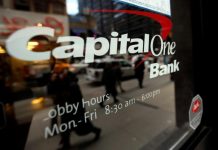People walk past a Capital One banking center in New York's financial district