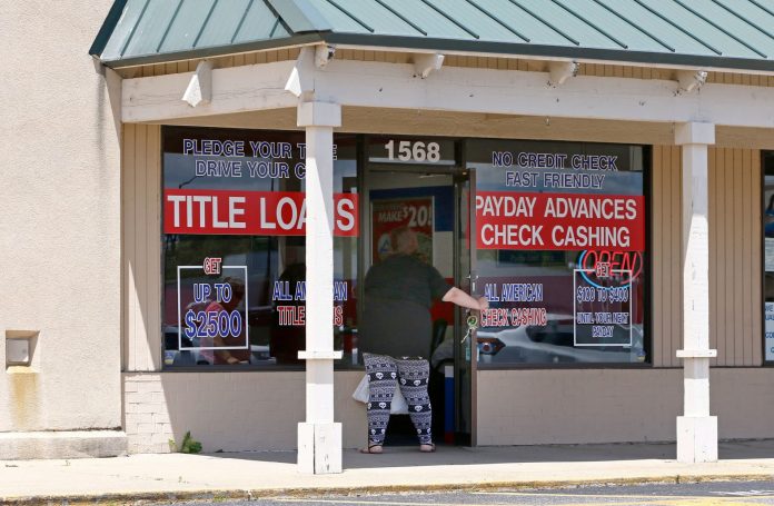A woman enters an All American Check Cashing location in Brandon, Miss