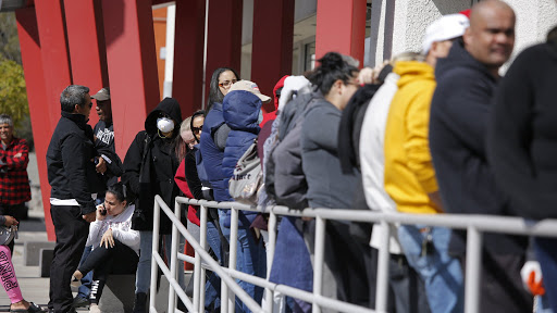 People wait in line for help with unemployment benefits at the One-Stop Career Center, Tuesday, March 17, 2020, in Las Vegas. Nevada Department of Employment, Training and Rehabilitation and its partner organizations, like the One-Stop Career Center, have seen an increase in traffic due to the coronavirus. (AP Photo/John Locher)
