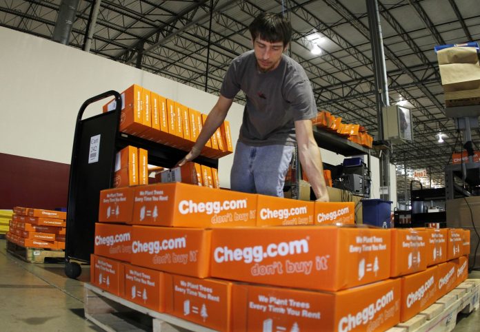 James Tahaney loads textbooks on to a pallet in preparation for shipping at the Chegg Inc. warehouse in Shepherdsville, Kentucky, U.S.