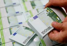 An employee checks 100 Euro banknotes at the Money Service Austria company's headquarters in Vienna, Austria, November 16, 2017. REUTERS/Leonhard Foeger - RC1EB5EB8000
