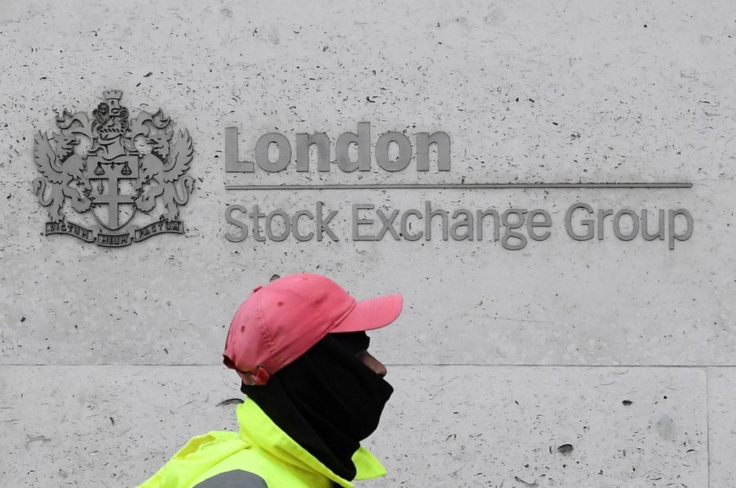 A street cleaning operative walks past the London Stock Exchange Group building in the City of London financial district, whilst British stocks tumble as investors fear that the coronavirus outbreak could stall the global economy, in London, Britain