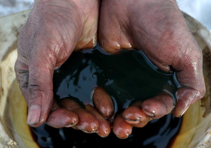 An employee holds a sample of crude oil at the Yarakta oilfield, owned by Irkutsk Oil Co, in the Irkutsk region