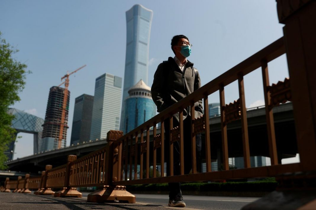 A walks by Beijing's Central Business District during morning rush hour as the spread of the new coronavirus disease (COVID-19) continues in China