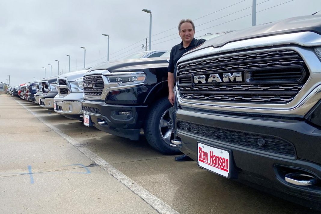 Jerry Bill, general manager of Stew Hansen Chrysler Dodge Jeep Ram, poses among a line of Ram trucks that he fears will be in very short supply by June if consumer demand remains strong, in Urbandale, Iowa, U.S.