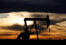 The sun sets behind a crude oil pump jack on a drill pad in the Permian Basin in Loving County, Texas, U.S.