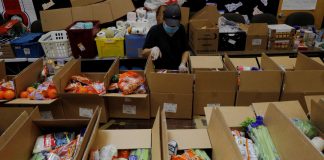A worker prepares boxes of free food for distribution at the Chelsea Collaborative, which distributes 6 to 7 thousand of boxes of food a week in a city hard hit by the coronavirus disease (COVID-19) outbreak, in Chelsea, Massachusetts, U.S., July