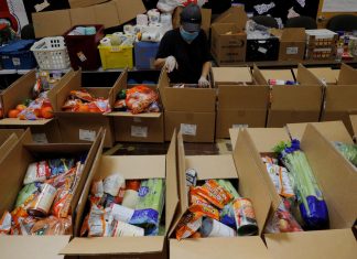 A worker prepares boxes of free food for distribution at the Chelsea Collaborative, which distributes 6 to 7 thousand of boxes of food a week in a city hard hit by the coronavirus disease (COVID-19) outbreak, in Chelsea, Massachusetts, U.S., July